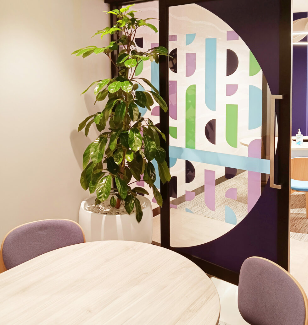 A private office with vibrant geometric decals, cozy seating, and natural accents.