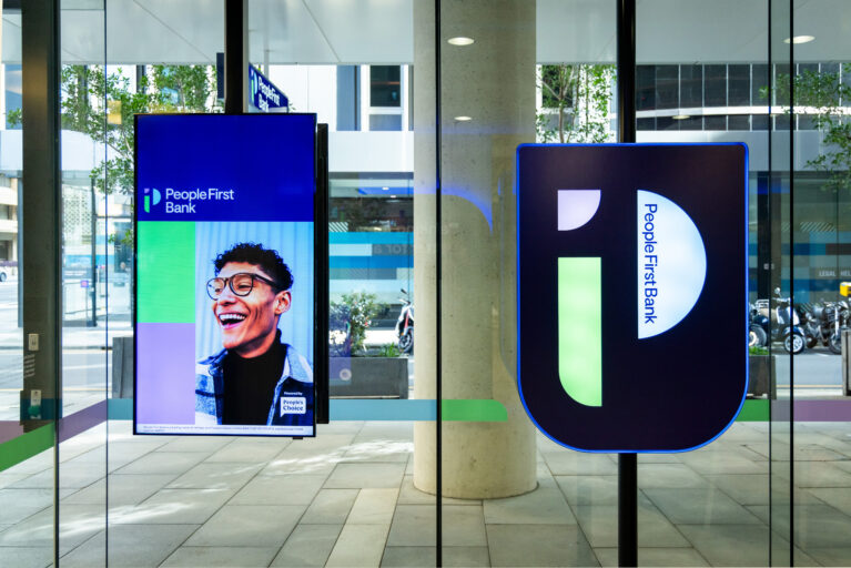 A vibrant digital display greets visitors, showcasing People First Bank’s commitment to community and inclusivity.