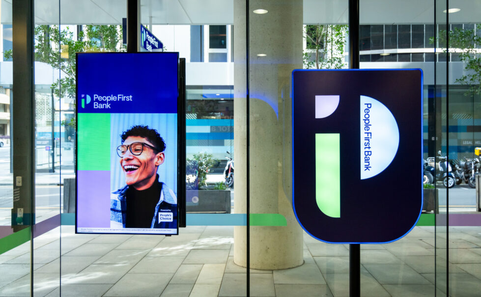 A vibrant digital display greets visitors, showcasing People First Bank’s commitment to community and inclusivity.