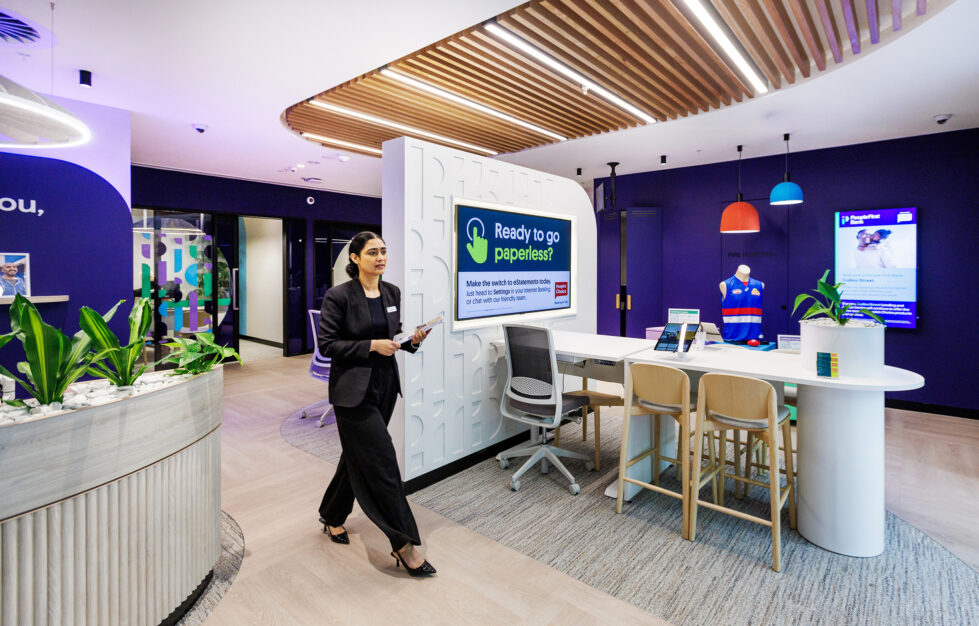 This open-plan workspace redefines banking environments with clean lines, a light warm palette, and flexible seating options. Contemporary design elements like textured walls, natural wood tones, and integrated greenery create a modern, approachable, and inclusive atmosphere for staff and visitors alike.