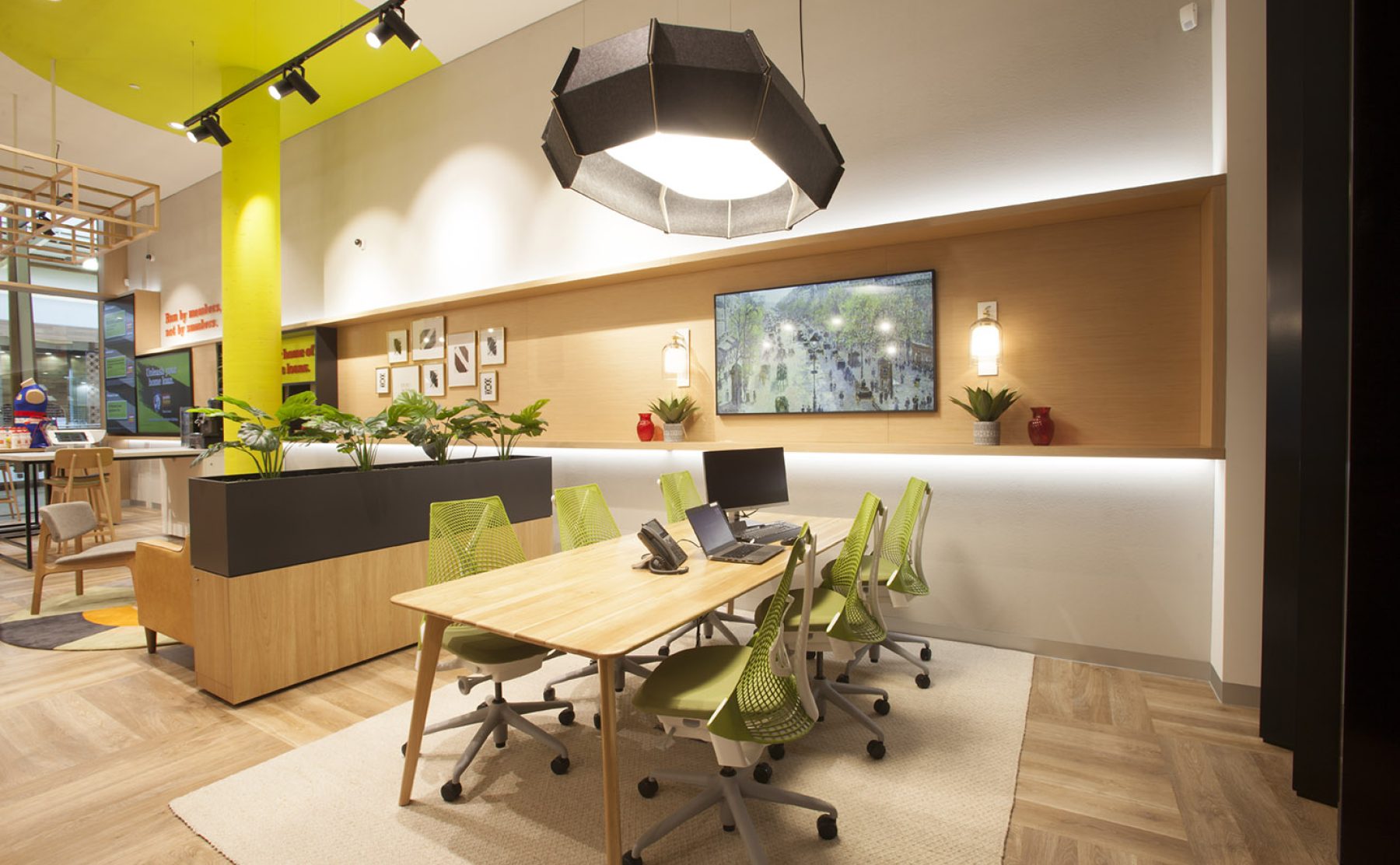 A dedicated advisory zone featuring ergonomic seating and a bespoke timber meeting table.