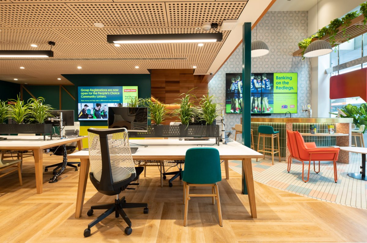 Modern "conversation desks" near the bar at People’s Choice bank, offering a comfortable, collaborative environment with vibrant seating and natural accents.