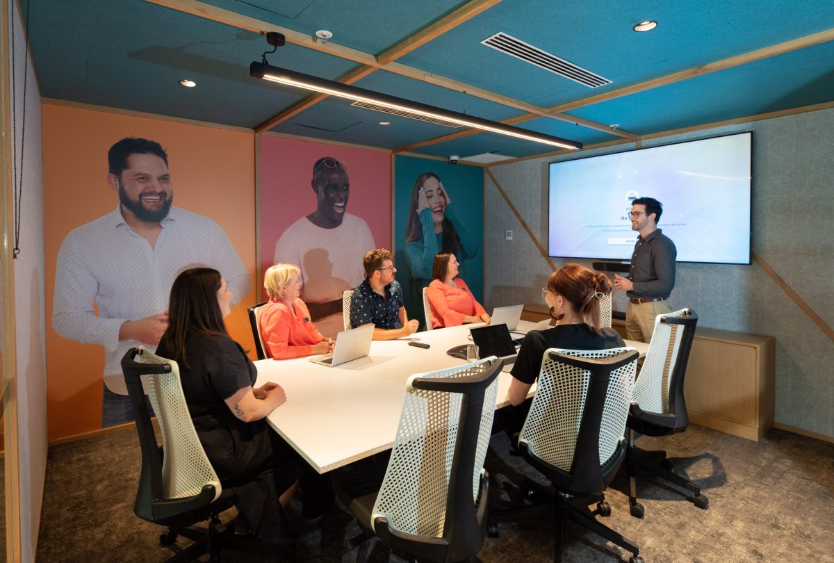 A vibrant, modern meeting room at People’s Choice bank, featuring soft tones, artistic murals, and ergonomic furnishings.