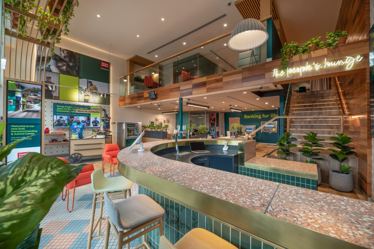 The lower level of People’s Choice bank, featuring the vibrant community wall and a stylish bar area with sports memorabilia celebrating local partnerships.