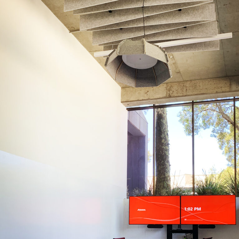 Elegant boardroom with wave-pattern acoustic ceiling and natural light.