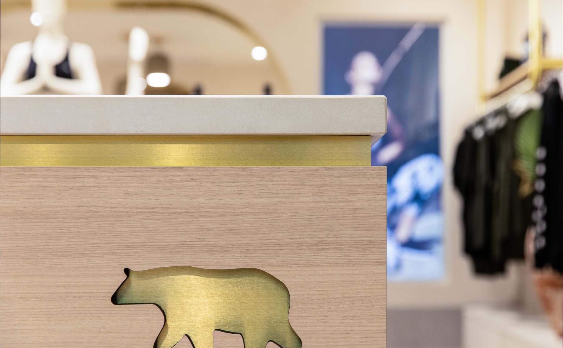 Close-up of a timber counter featuring an inlaid brass logo and matching shadow gap.