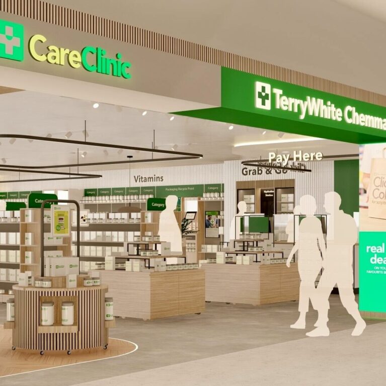 An open view through the TerryWhite Chemmart entrance, framed by bright signage and flexible display pods on wheels that guide customers toward vitamins, Grab & Go and the Pay Here counter.