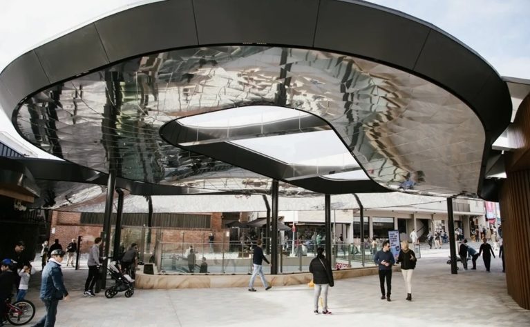 The signature canopy of the plaza, a reflective architectural centerpiece that blends shelter with urban style.