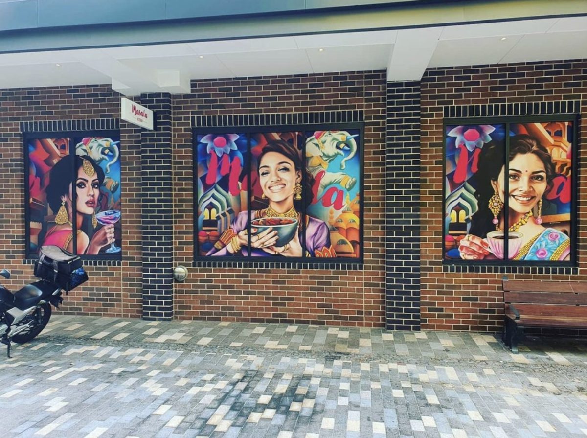 The Masala Laneway with vibrant murals and a warm brick facade, creating a cultural and artistic atmosphere.
