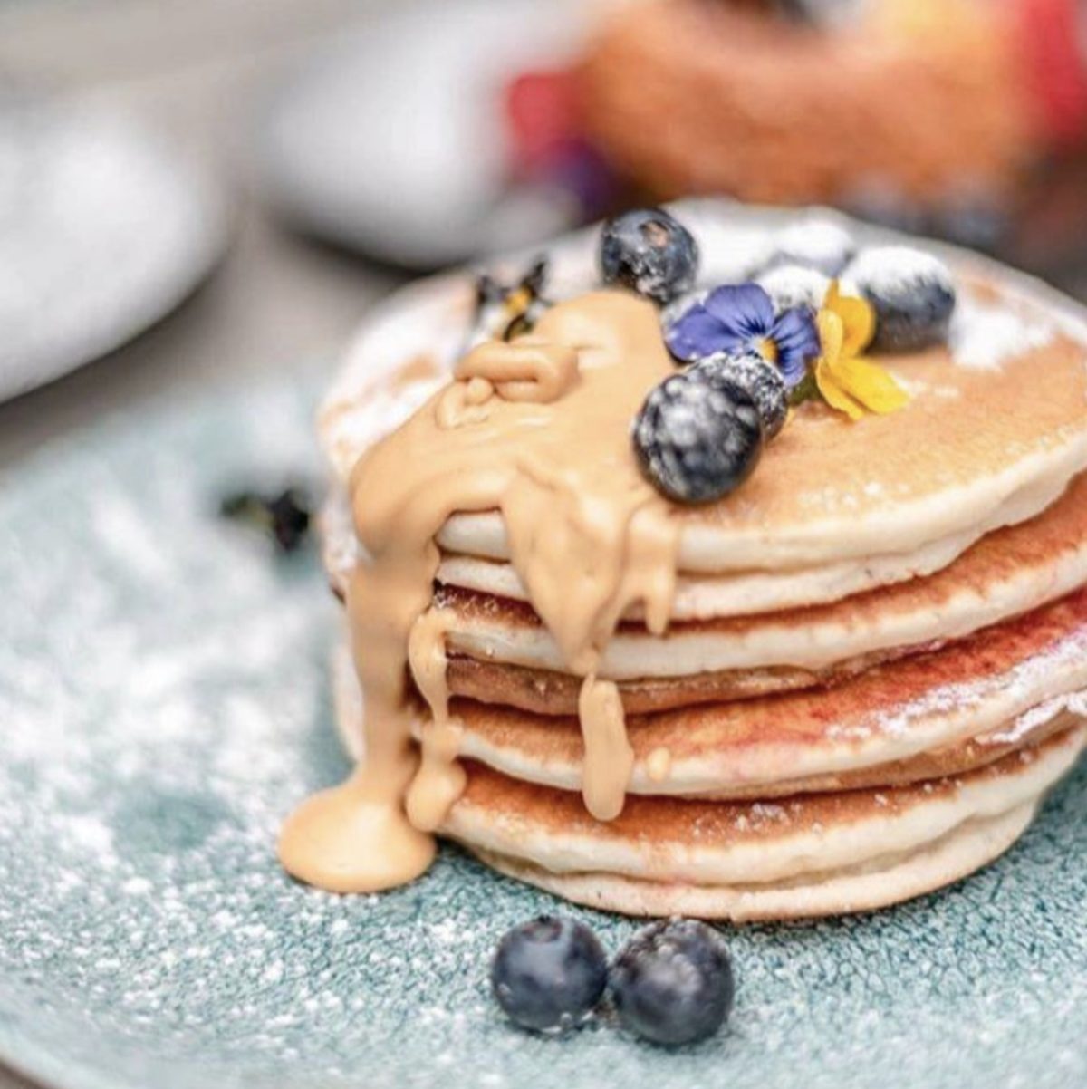 A close-up of a decadent pancake at Peanut Butter Jelly, set against the backdrop of the restaurant’s vibrant and artistic ambiance.