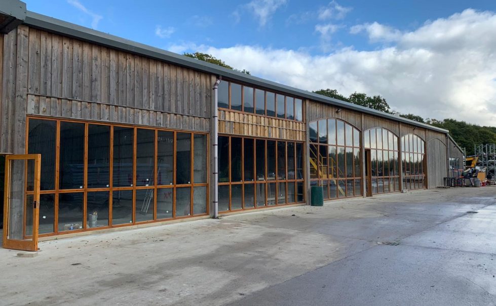 The Mason’s Yard exterior, a barn conversion into a creative showroom, showcasing J Rotherham’s legacy in a spacious, wooden structure.