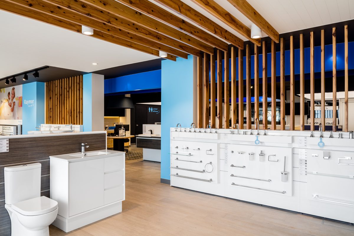 Commercial tapware display, white timber showroom wall, bathroom vanity unit, ceramic toilet suite, architectural timber ceiling baffles, raw wood pole privacy screen, trade showroom floor plan.