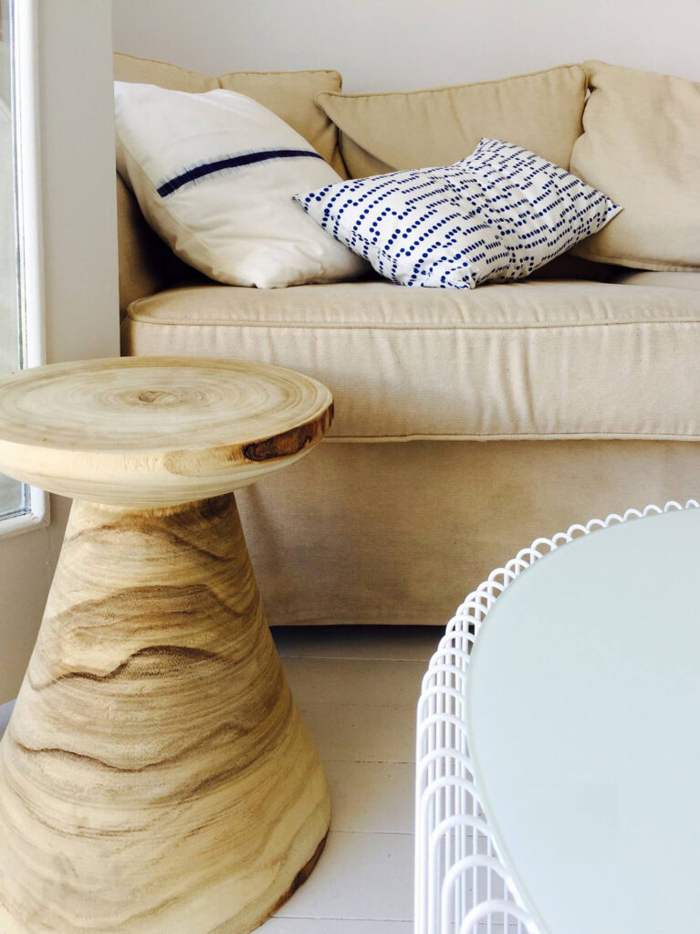 Textural accents and coastal tones define this inviting living area. Organic wood furniture and neutral textiles enhance the room’s relaxed, island-inspired charm.