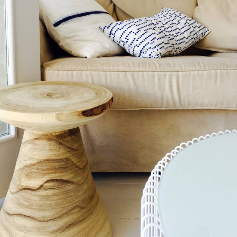 Textural accents and coastal tones define this inviting living area. Organic wood furniture and neutral textiles enhance the room’s relaxed, island-inspired charm.