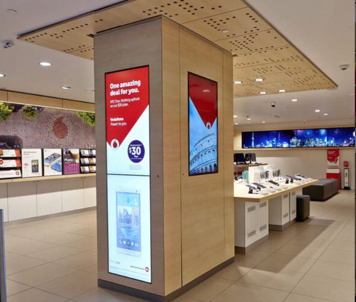 A sleek display pillar in the Vodafone store, featuring interactive screens for promotions and product information.