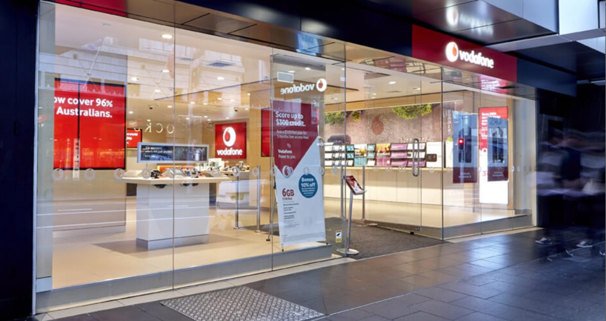 Vodafone store shopfront with large glass windows, showcasing a bright, organized interior and prominent branding.
