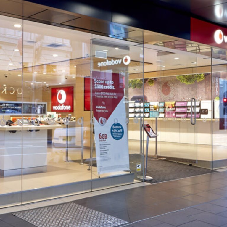 vodafone shopfront design including timber, glass and corporate red elements