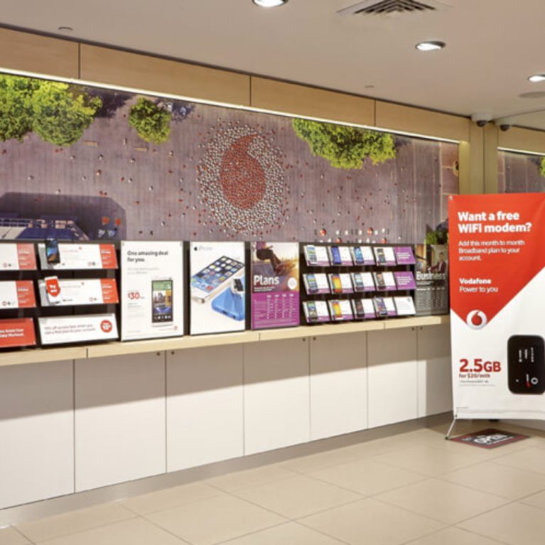 featured wall inside vodafone store including product display, oversized mural and storage